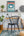 Modern home office with a black chair, wooden desk, and framed Alice In Wonderland book cover