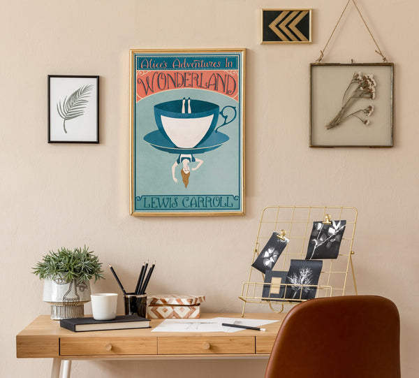 Home office with a desk, chair, and wall art including a poster of 'Alice's Adventures in Wonderland'.