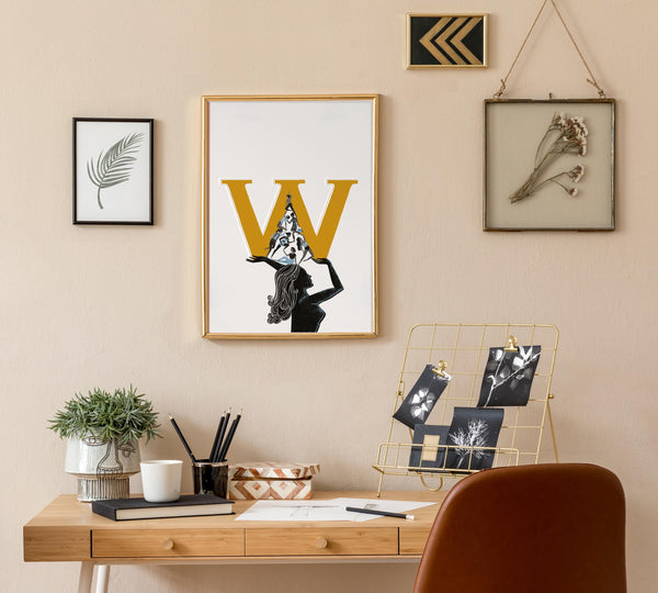 Home office setup with a desk, chair, and wall art featuring a large 'W' for International Women'sDay