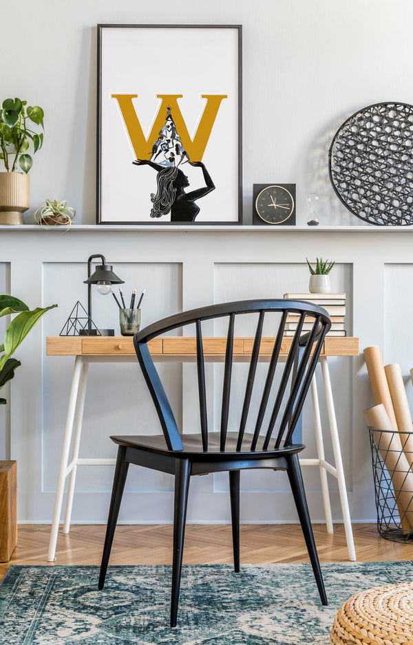 Modern home office with black chair, wooden desk, and International Women's Day Art on wall 