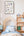 Children's bedroom with wooden bed, bookshelf, and Magic alphabet poster on the wall.
