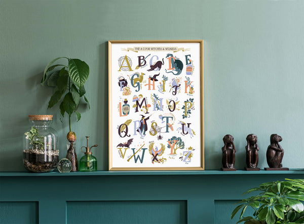 Framed Harry Potter Magic alphabet poster on a green wall with decorative items below