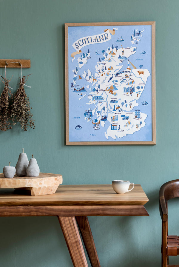 Map of Scotland on a wall above a wooden table with decor items.