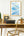 Framed artwork with motivational quote above a desk with a typewriter and chair.