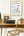 Framed 'Office Ergonomics' poster on a wall above a desk with a typewriter and chair.