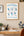 Framed Office Stretches poster on a wall above a desk with office decor elements.