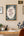 Home office with a desk, chair, and framed 'The Name of the Wind' by Patrick Rothfuss poster on the wall.