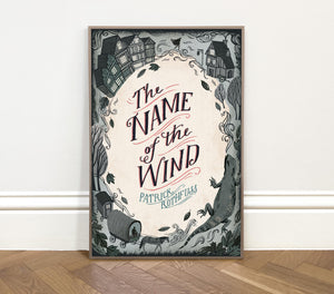 Framed book cover of 'The Name of the Wind' by Patrick Rothfuss on a white wall.