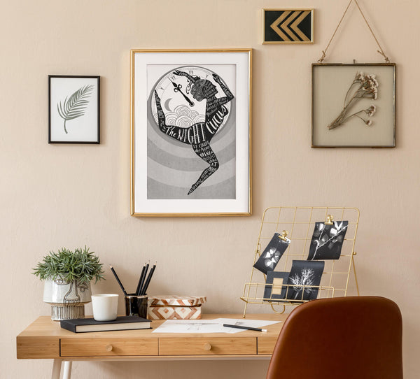 Home office with a desk, chair, and Framed artwork  of The Night Circus by  Erin Morgenstern 